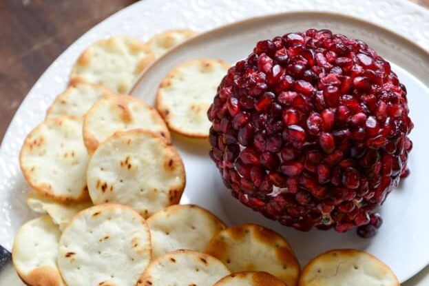 This Christmas food will wow your guests. Try making a beautiful pomegranate jeweled white cheddar cheeseball for an appetizer! | The Dating Divas