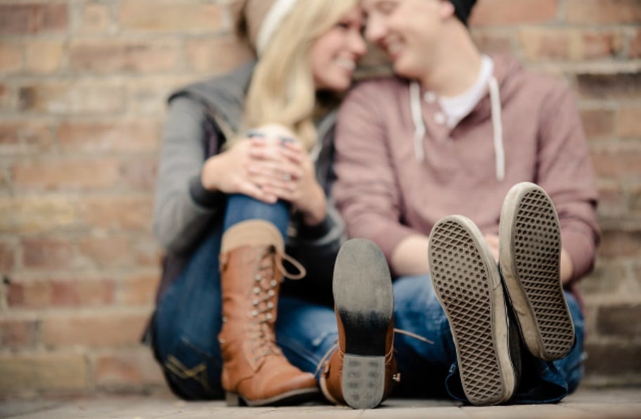 Winter engagement photos showing a couple leaning against a wall together | The Dating Divas