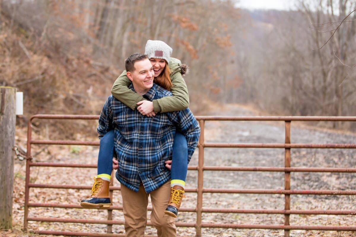 A winter image that shows a man giving his fiance a piggy back ride | The Dating Divas