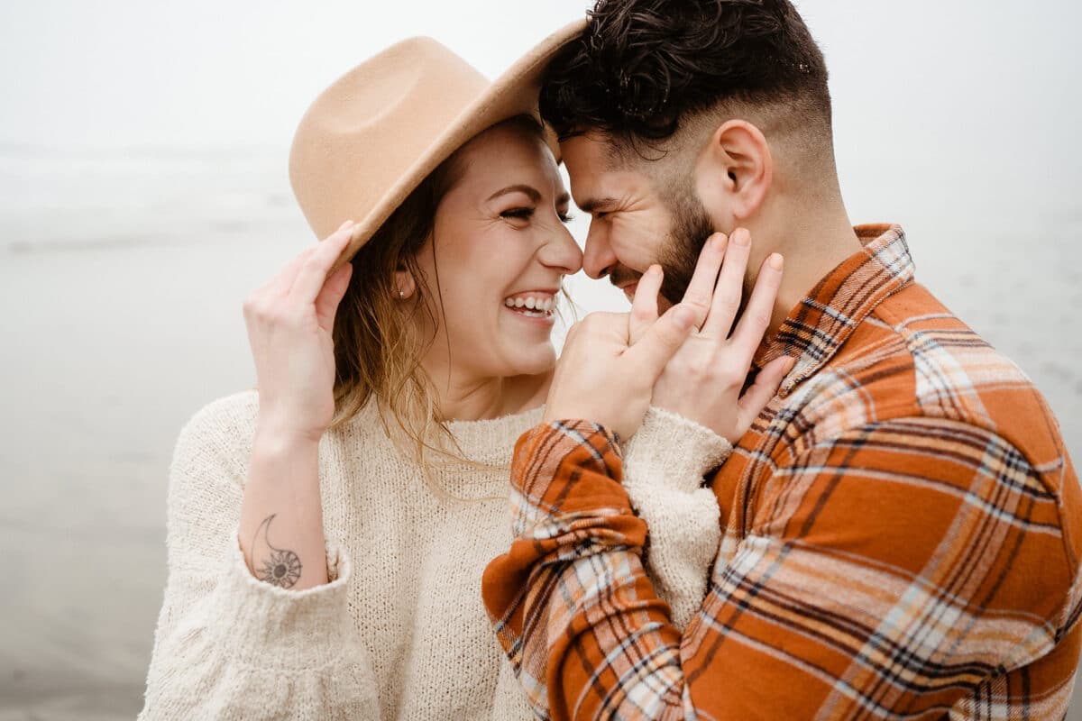 A man and woman posing closely together for their winter engagement photos | The Dating Divas
