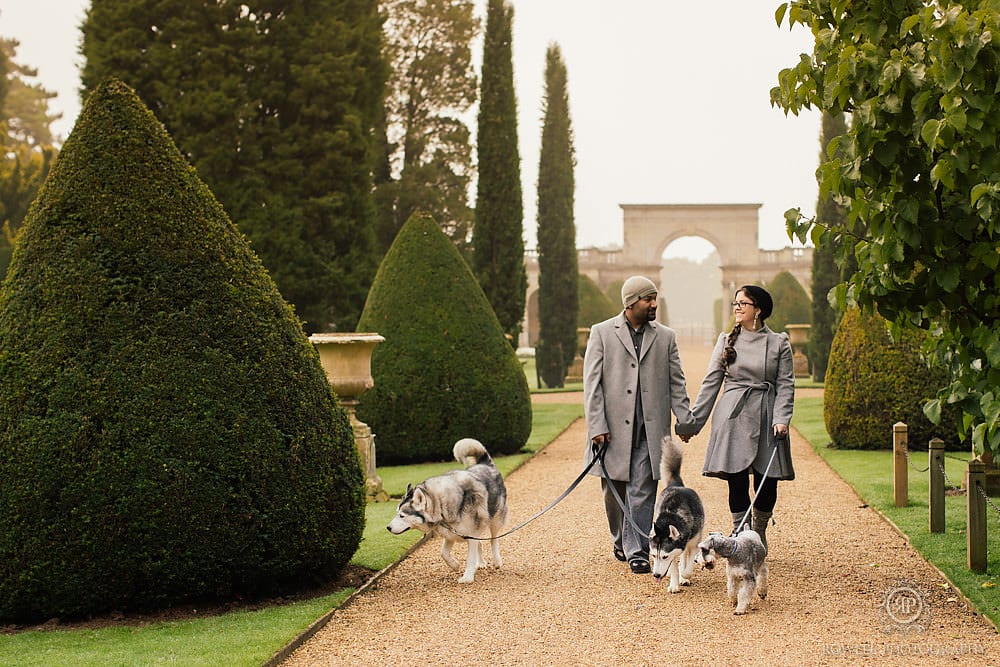 A couple walking their dogs during their winter engagement photos | The Dating Divas