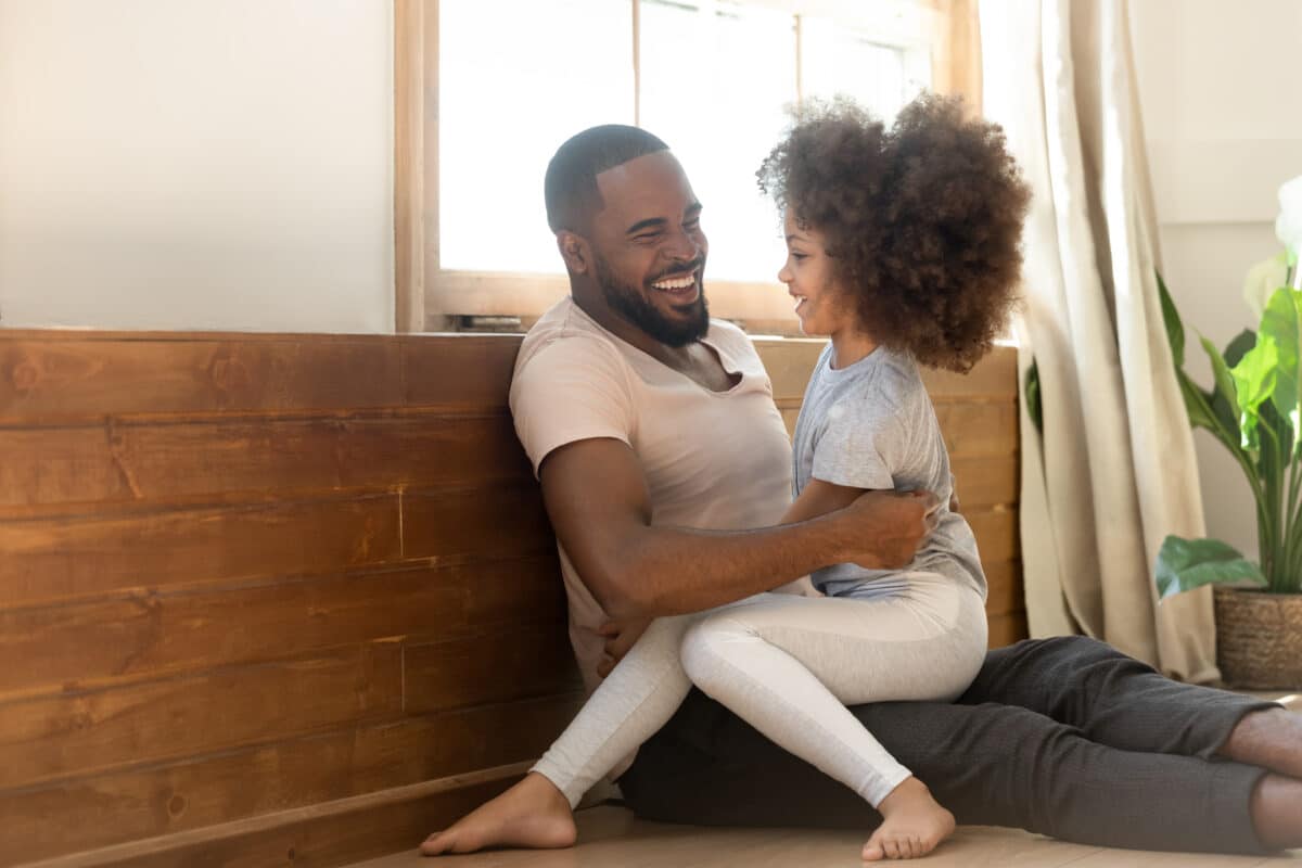 A father and daughter laugh together while telling jokes to each other. | The Dating Divas